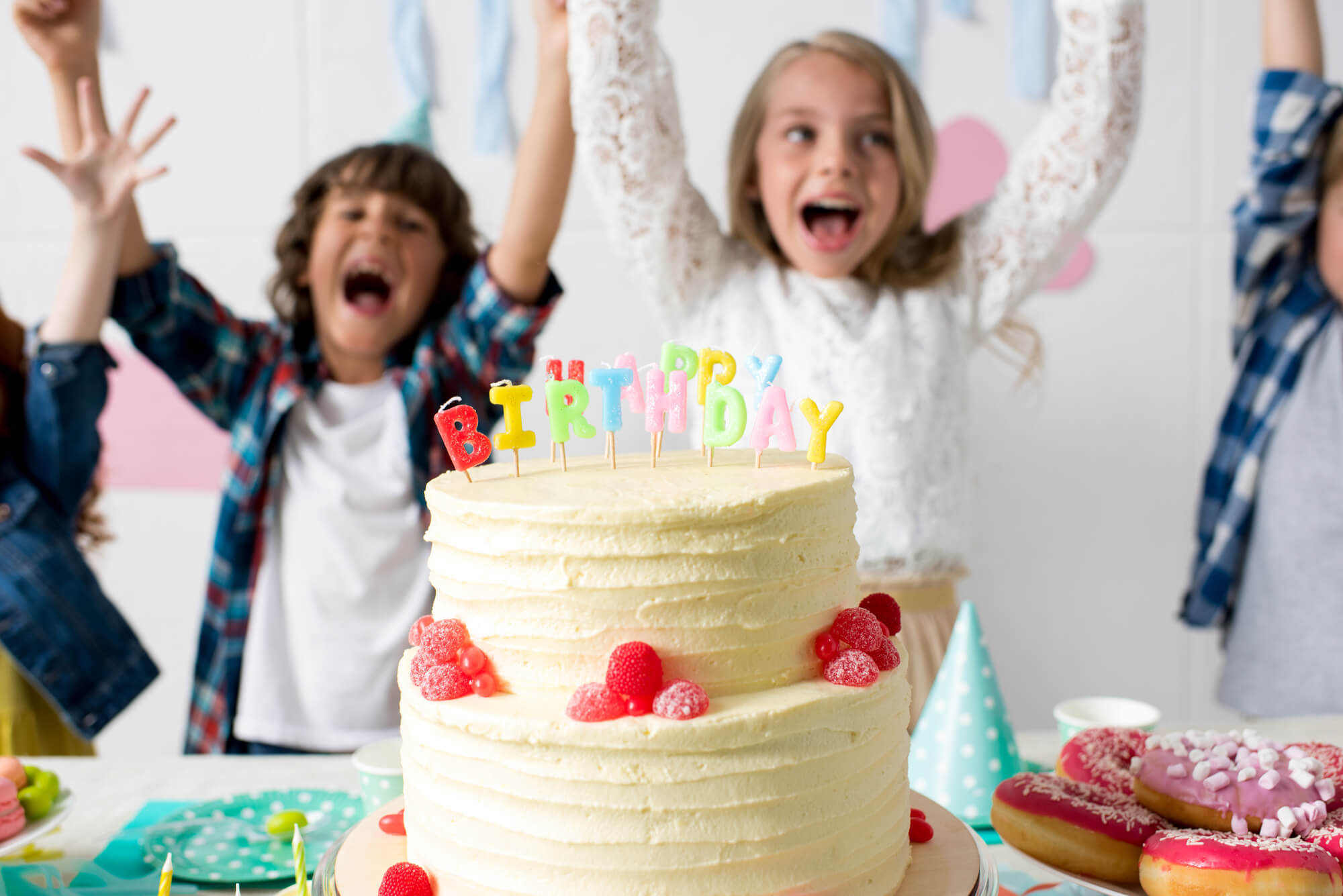 2 børn jubler over der bliver serveret kage til børnefødselsdag