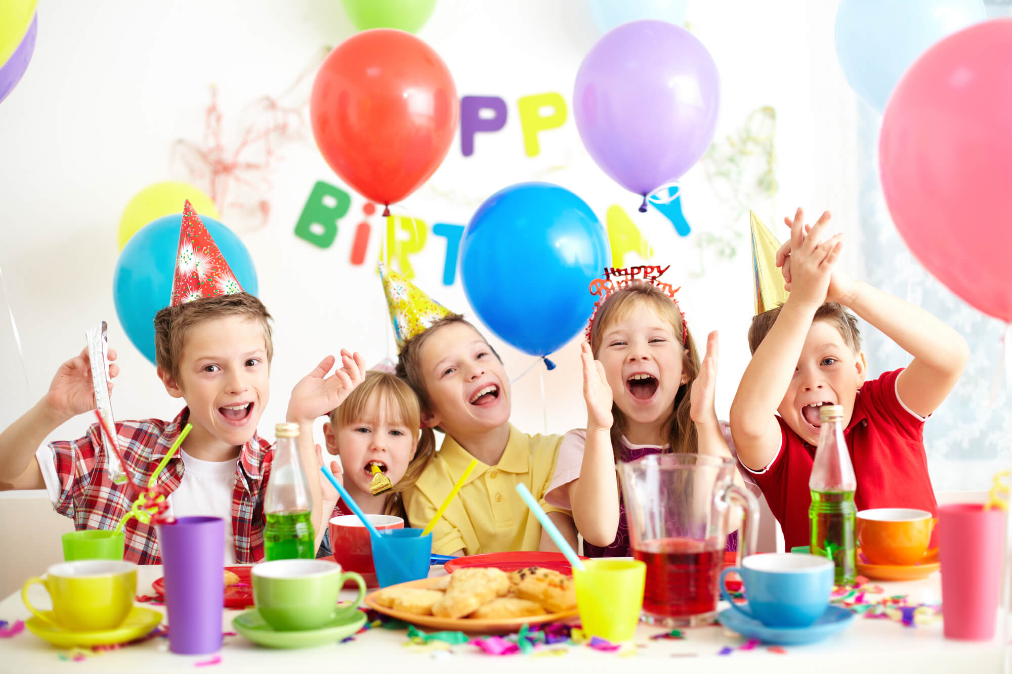 En gruppe børn sidder og griner mens de er til fødselsdag